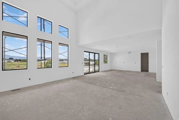Vaulted ceilings, a wall of six large windows, and a sliding glass door enhance this spacious room