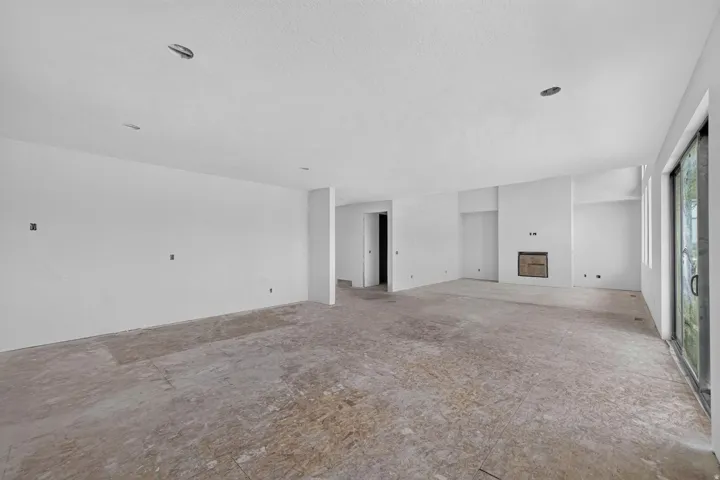 Spacious room with a built-in fireplace, recessed lighting, and large sliding glass doors
