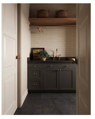Dedicated utility space featuring dark shaker-style cabinetry, a dark countertop, and a white subway tile backsplash