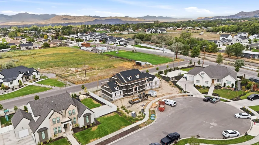 Newly constructed residence featuring a stone and stucco facade, a two-car garage, and a landscaped front yard
