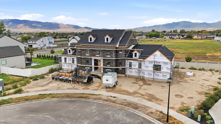 New construction residence featuring a multi-gable roofline, multiple dormer windows, and a partially finished exterior