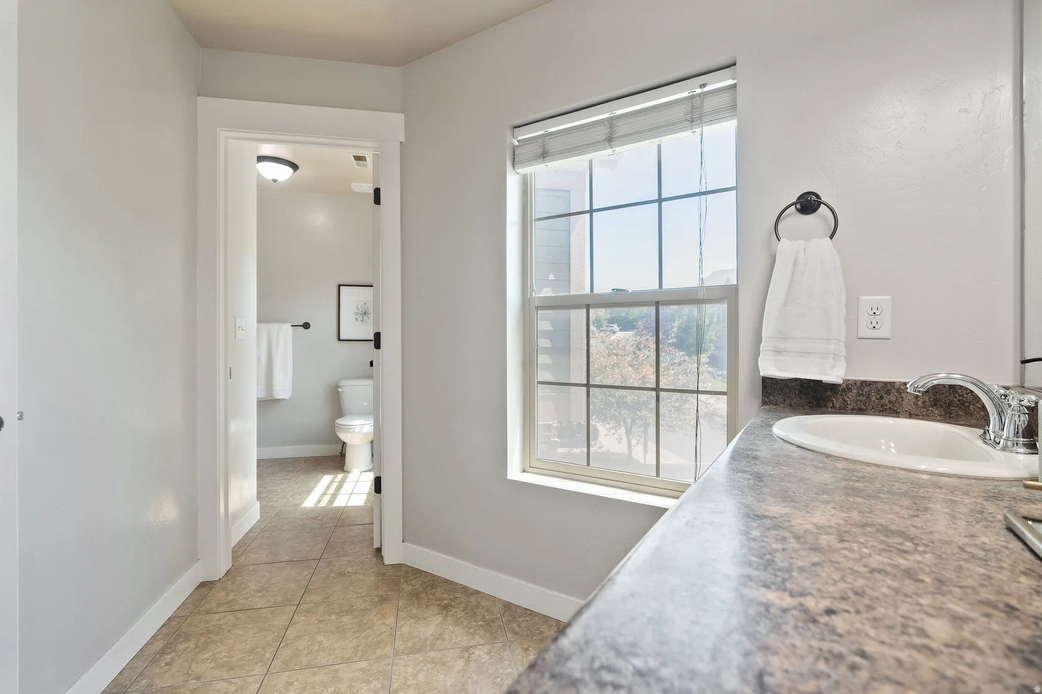 Bathroom vanity featuring an integrated sink with chrome faucet and a patterned countertop