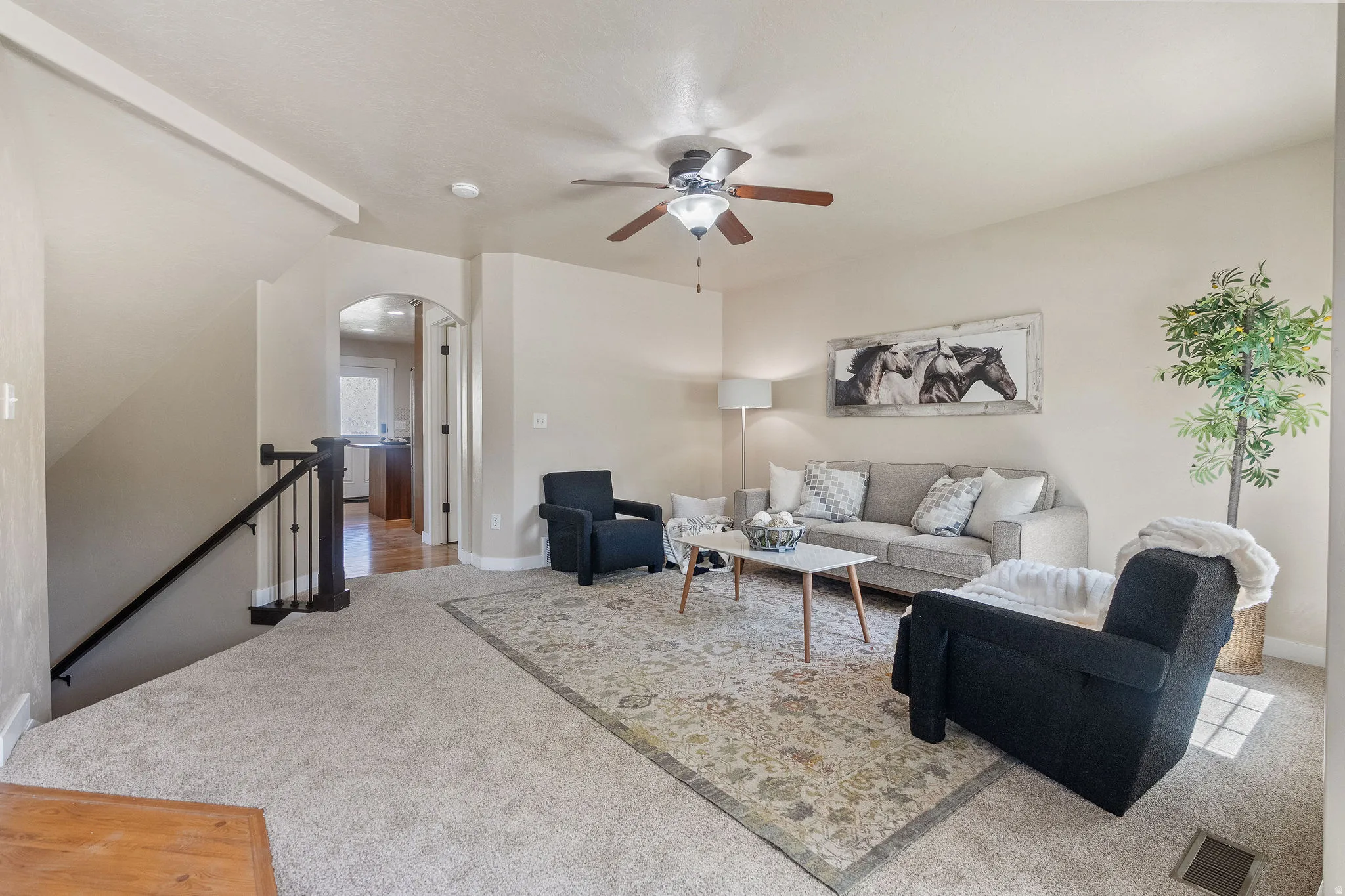 Spacious living area featuring neutral carpeting and light wall tones