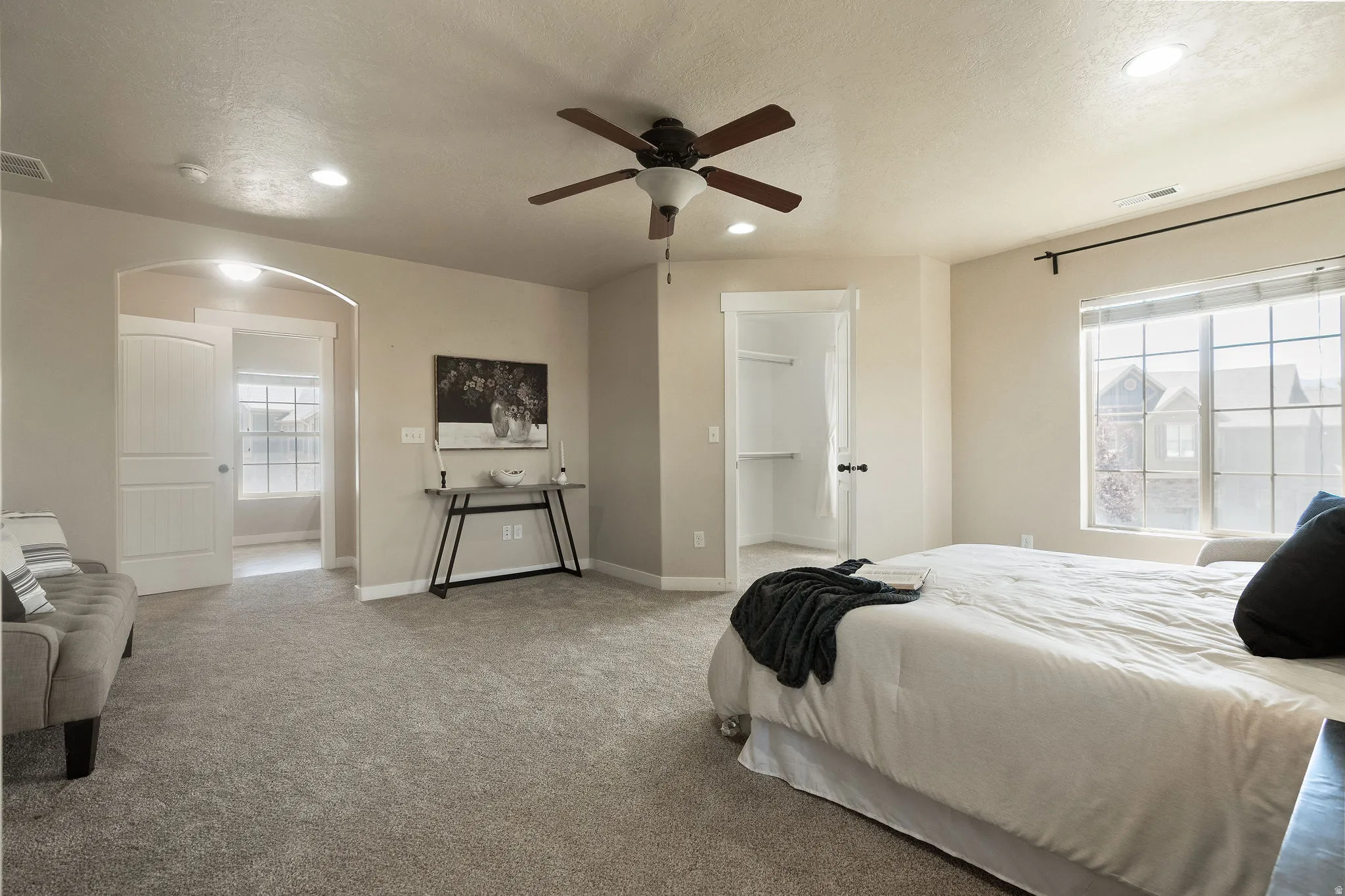 Carpeted room featuring a ceiling fan, recessed lighting, and a large window with white trim