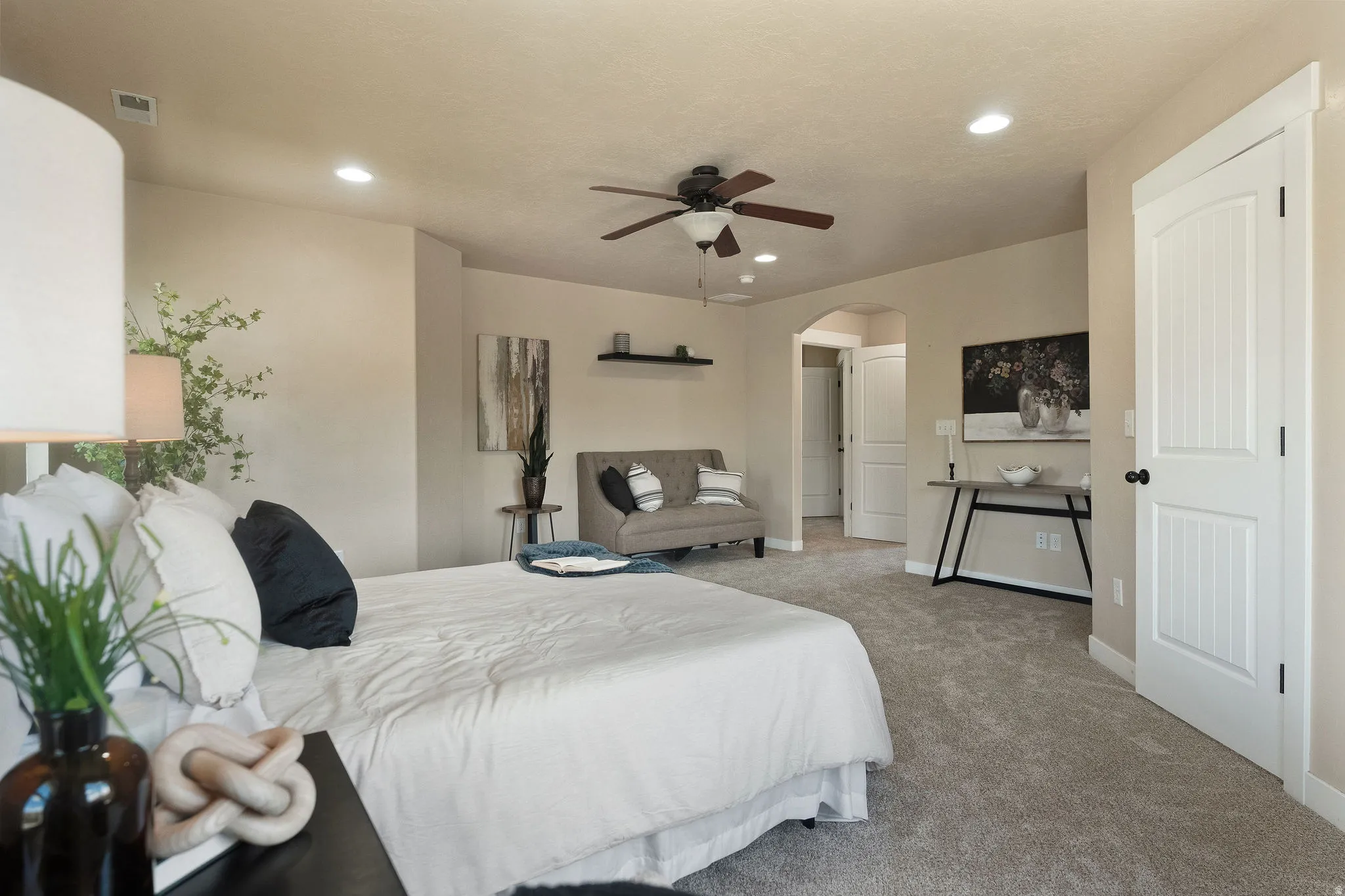 Spacious bedroom featuring neutral wall tones, recessed lighting, and a ceiling fan