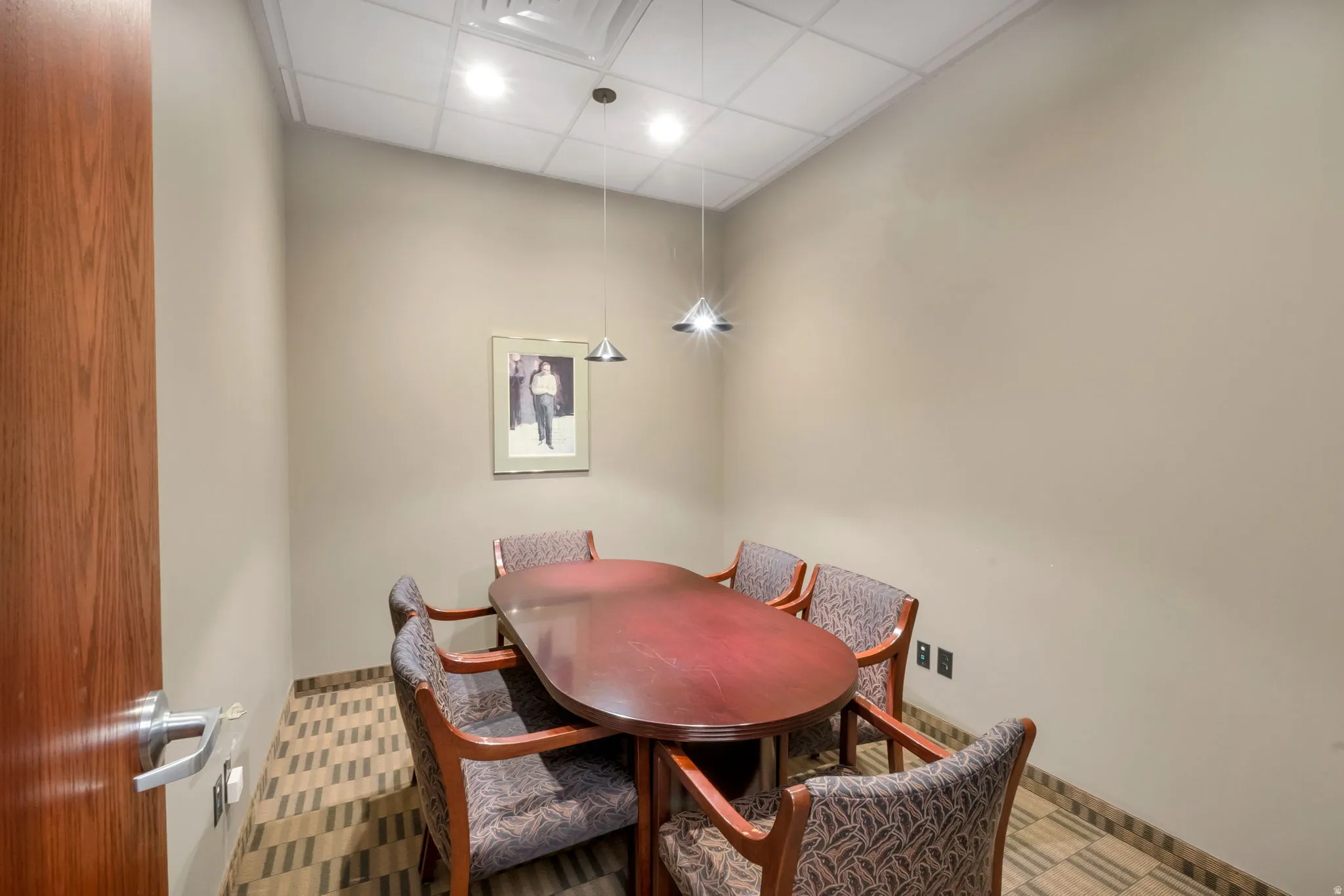 Compact room featuring an acoustic tile ceiling with recessed lighting and pendant fixtures