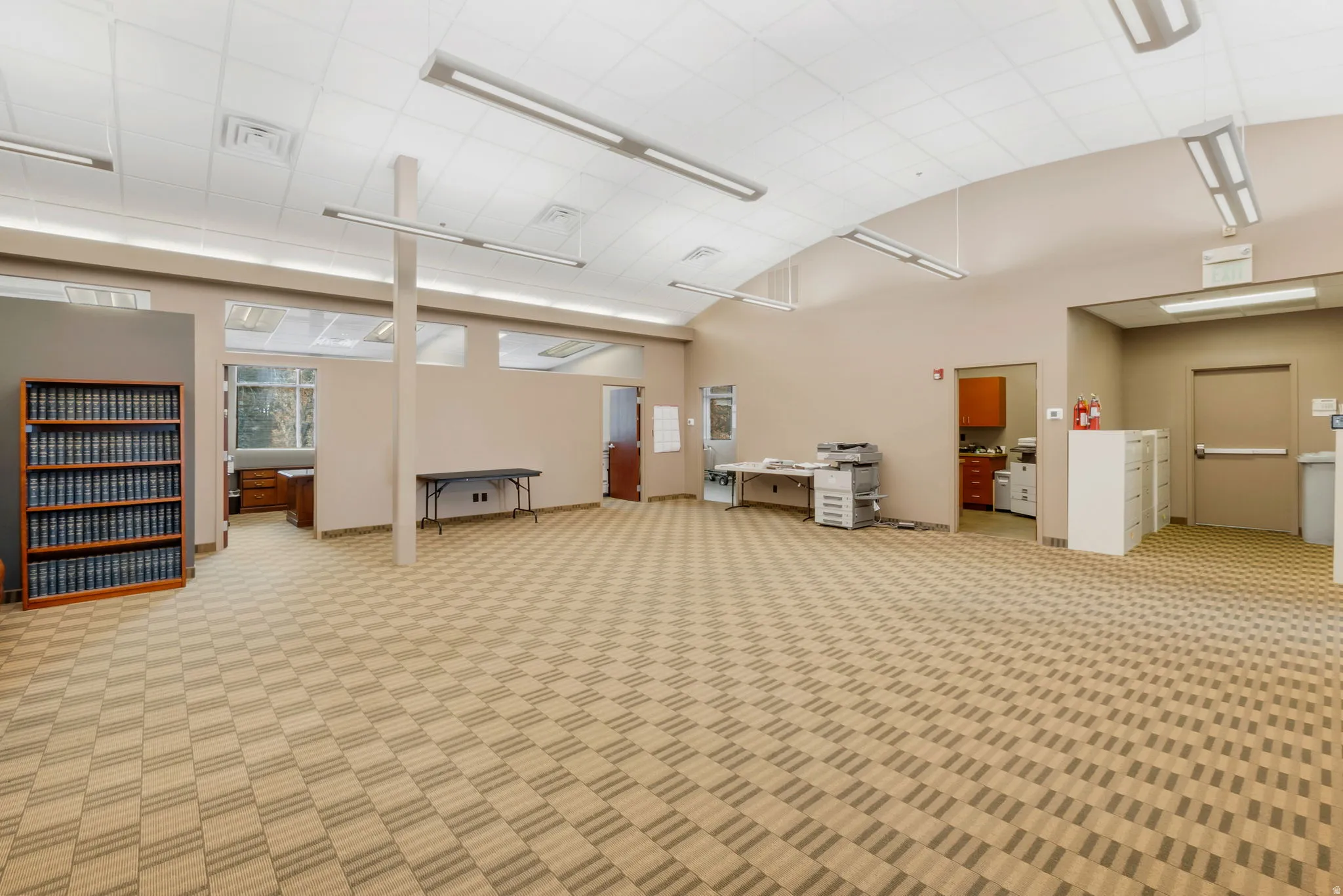 Spacious interior with neutral-toned walls and patterned carpet flooring