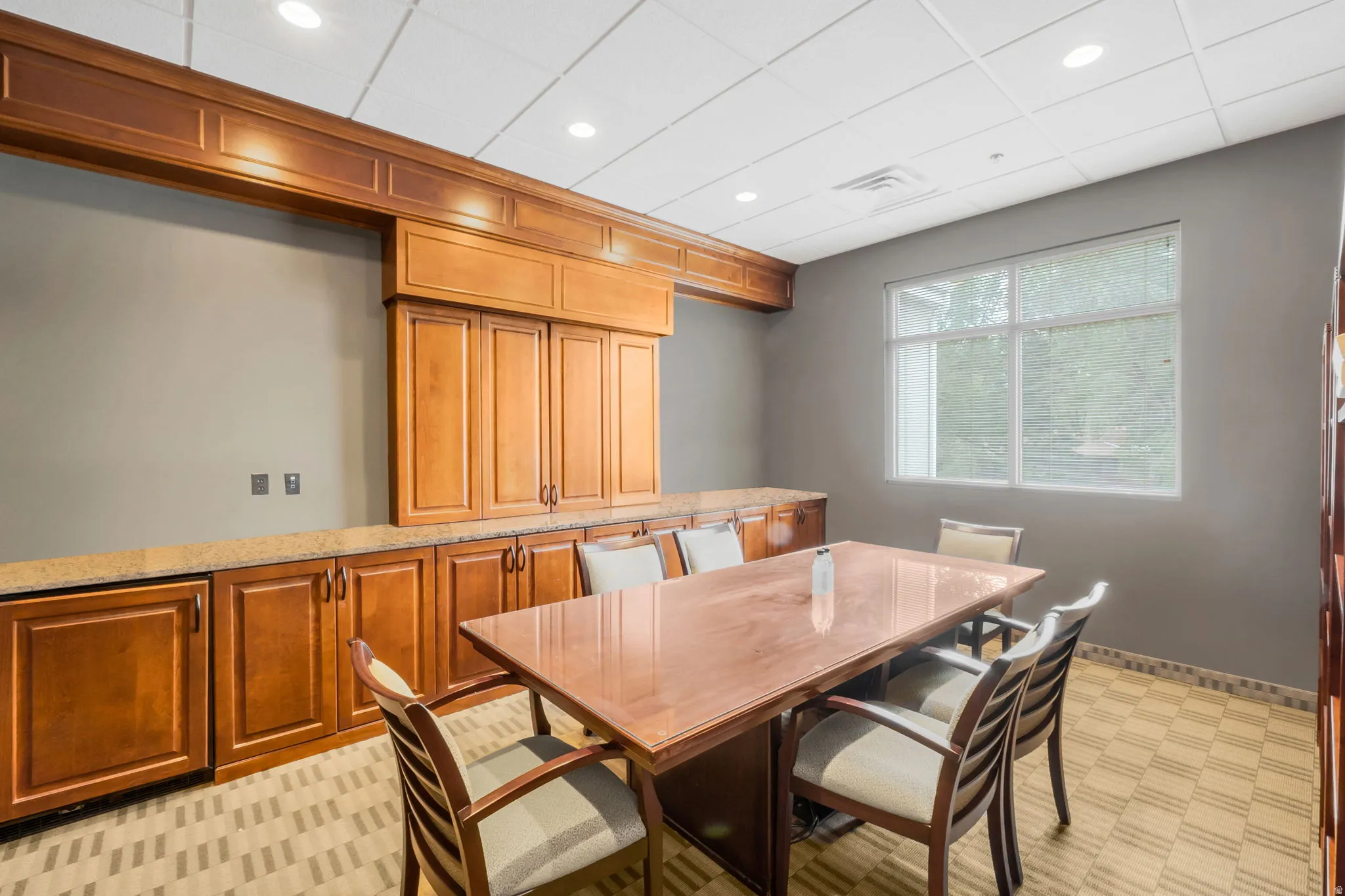 Conference Room with Built-in wood cabinetry with a light-toned countertop, a large window, recessed lighting, and patterned carpet