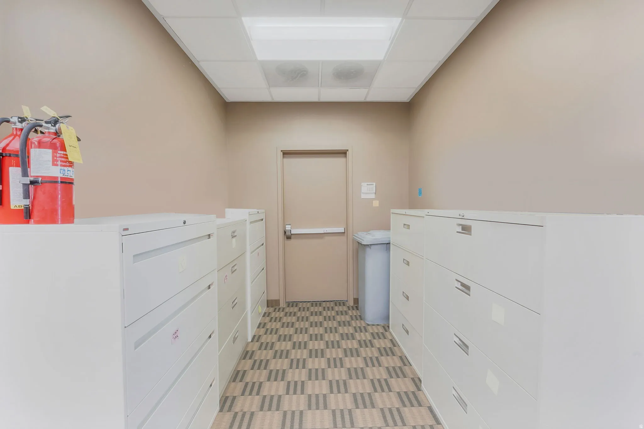 Hallway featuring neutral wall paint and a patterned floor