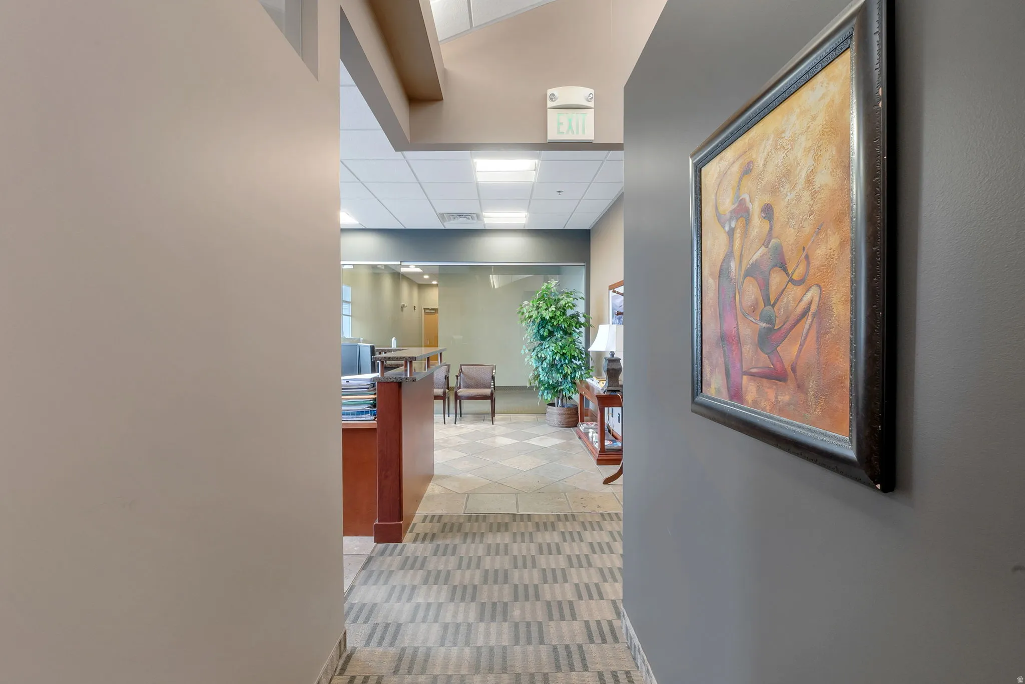Hallway with patterned carpet flooring leading to a reception area