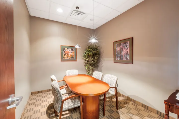 Compact room featuring recessed lighting, a drop ceiling, wood-finish door, and patterned floor tiles