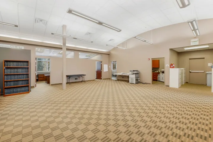 Spacious interior with neutral-toned walls and patterned carpet flooring