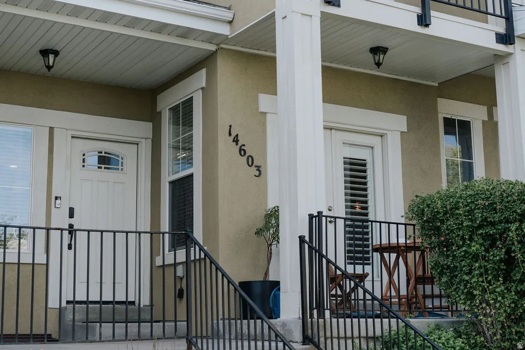 Stucco exterior featuring white trim and black iron railings