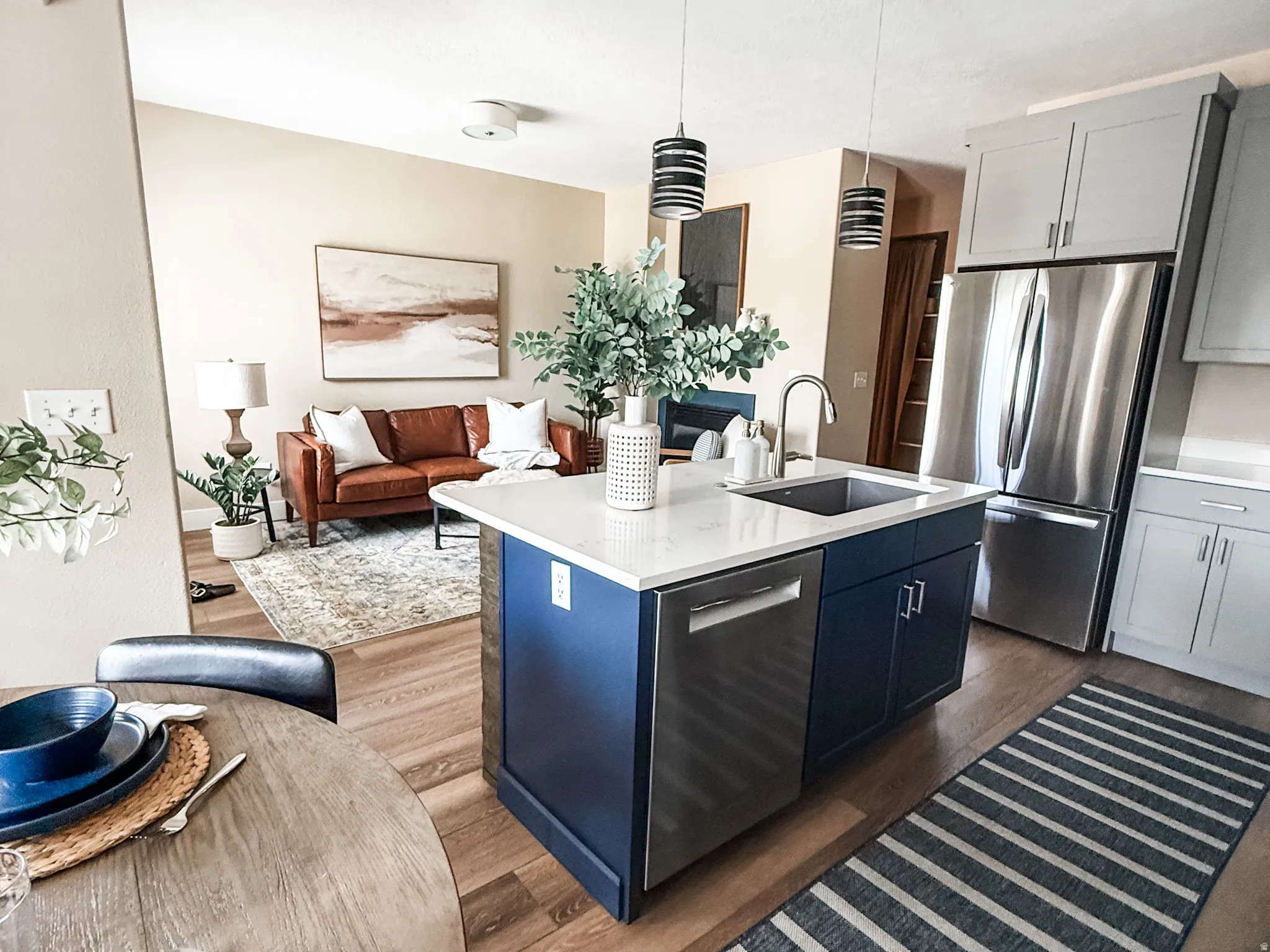 Kitchen island featuring a white countertop, undermount sink, and blue cabinetry
