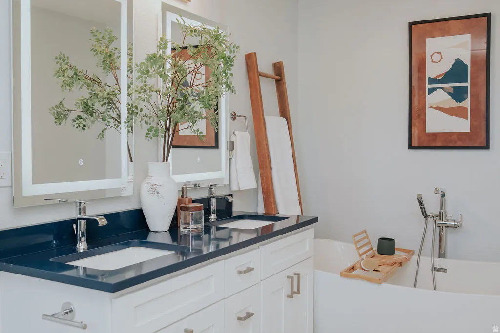 Dual vanity with white cabinetry, deep blue countertop, and integrated sinks