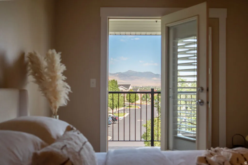 Balcony access from the interior room, featuring an outdoor railing and distant mountain scenery