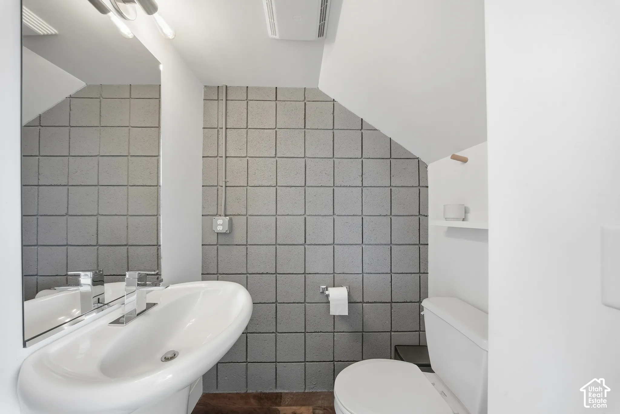 Pedestal sink with chrome faucet hardware, full-width wall mirror, and modern overhead lighting