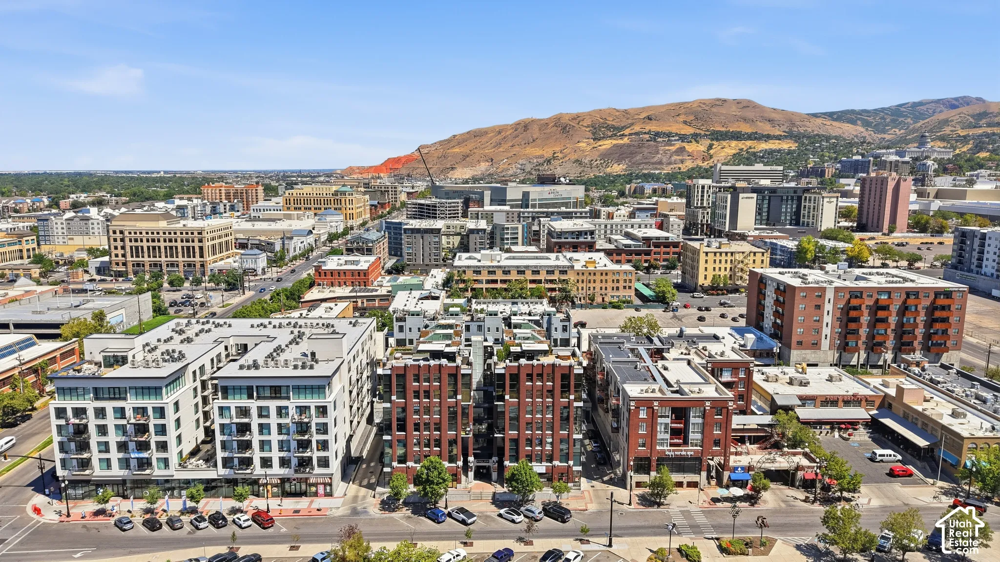 Expansive urban landscape featuring a mix of modern and traditional architecture, with a prominent mountainous backdrop