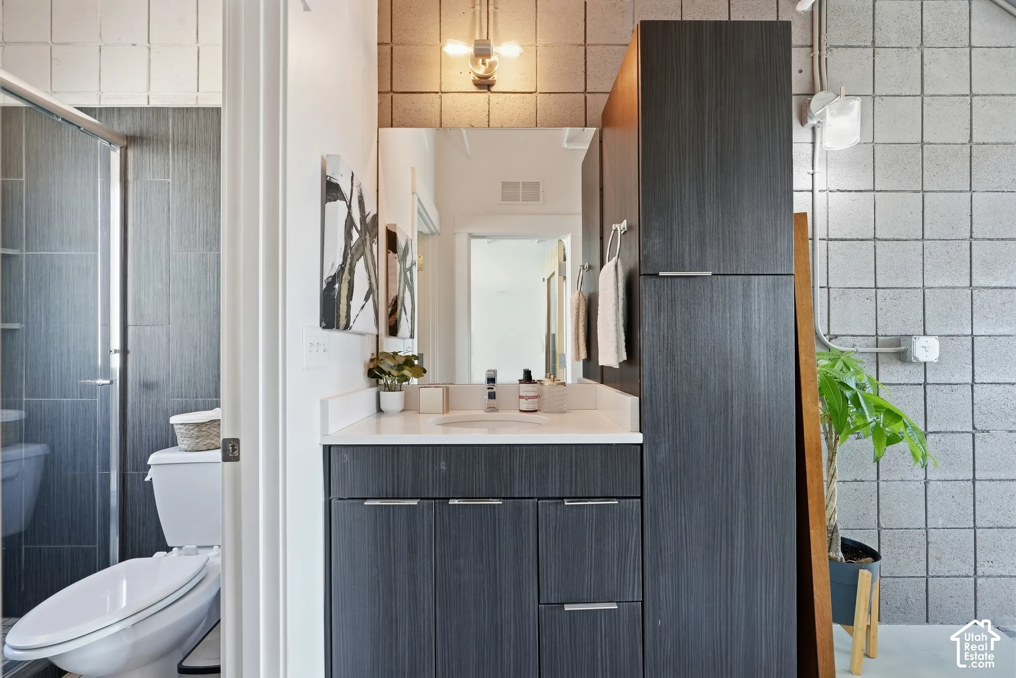 Contemporary bathroom featuring a dark wood-finish vanity with a white countertop and rectangular sink
