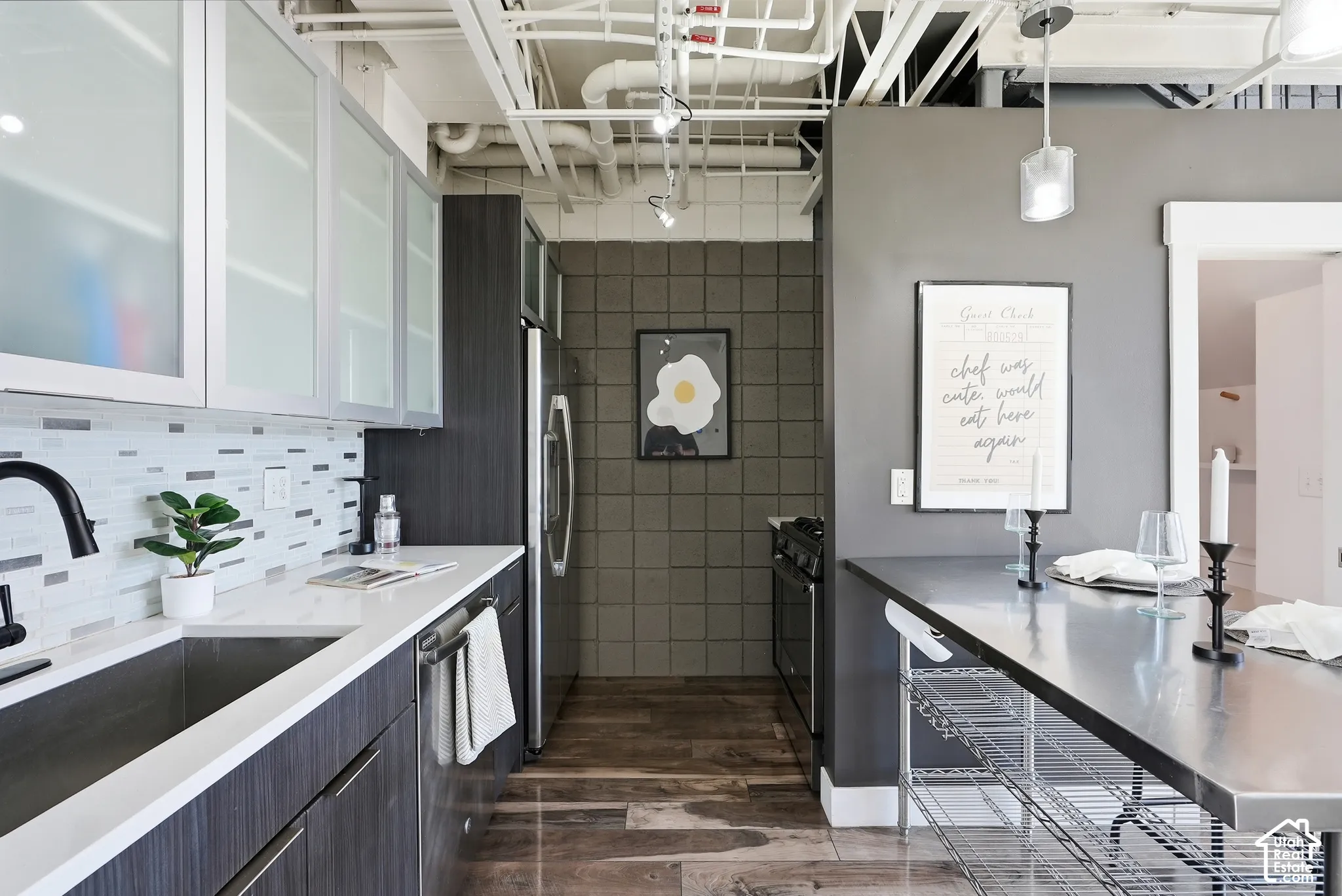 Contemporary kitchen featuring dark wood-finish cabinetry, white countertops, and a mosaic tile backsplash