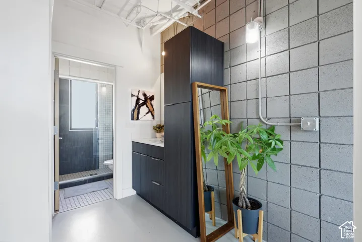 Bathroom featuring a dark wood-finish vanity with a white countertop and contemporary hardware
