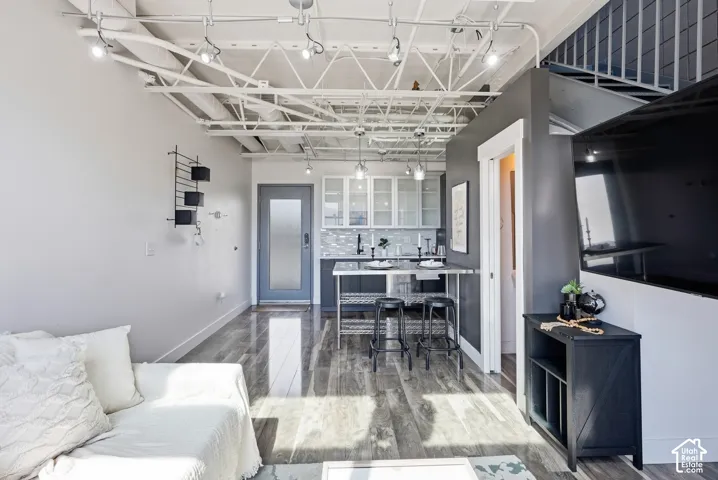 Open-concept living space with exposed ceiling trusses and track lighting