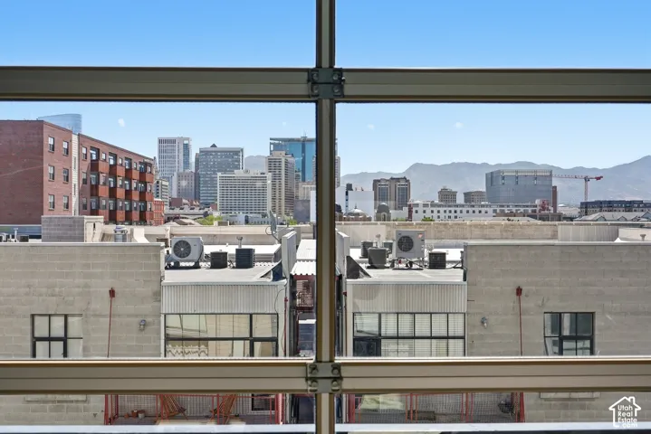 Expansive city skyline and distant mountain range framed by structural window elements