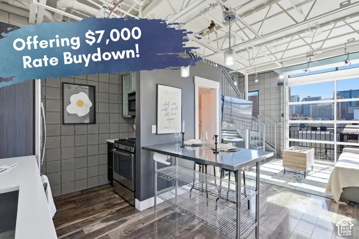Exposed ceiling trusses, full-height windows, stainless steel appliances, spiral staircase, and wood-finish flooring