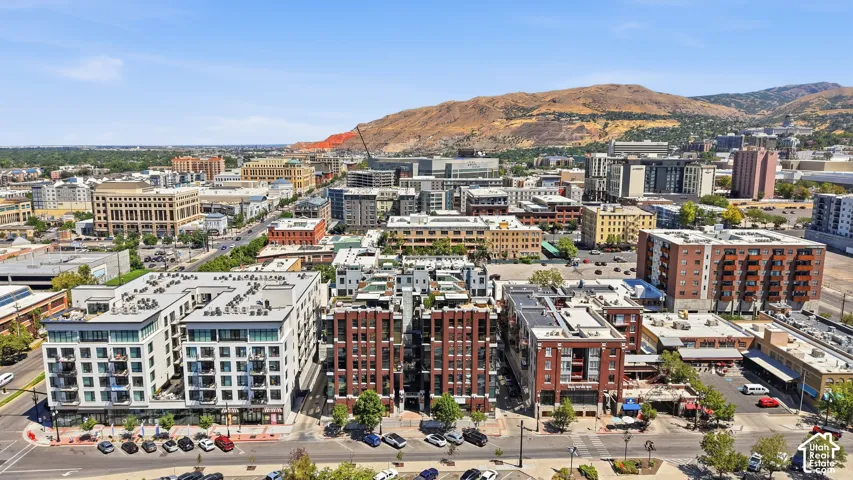 Expansive urban landscape featuring a mix of modern and traditional architecture, with a prominent mountainous backdrop