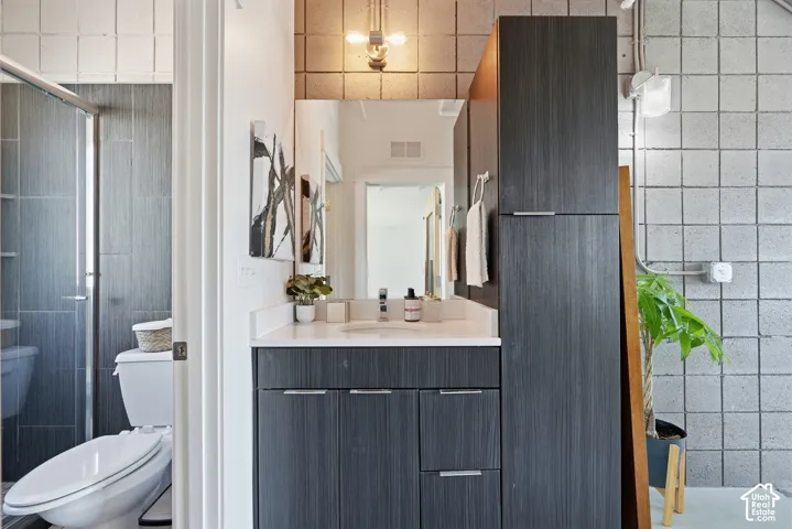 Contemporary bathroom featuring a dark wood-finish vanity with a white countertop and rectangular sink