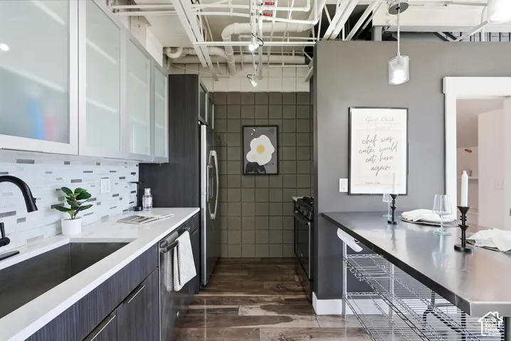Contemporary kitchen featuring dark wood-finish cabinetry, white countertops, and a mosaic tile backsplash