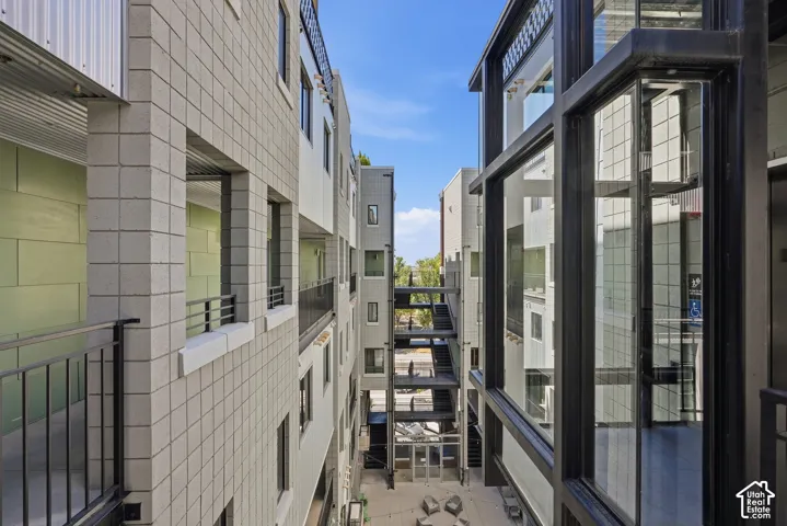 Modern building exterior featuring square block facade, dark-framed windows, and metal railings