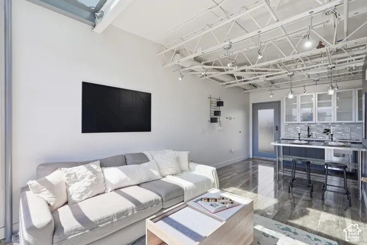 Open-concept living area with high ceilings featuring exposed ductwork and track lighting