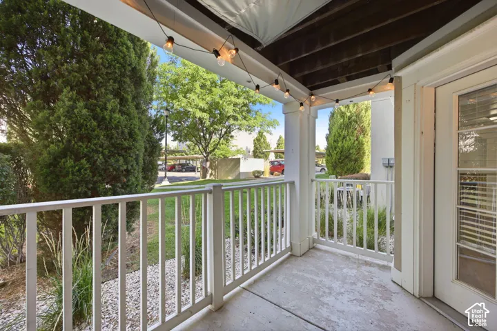 Patio featuring concrete flooring, white railings, and string lighting