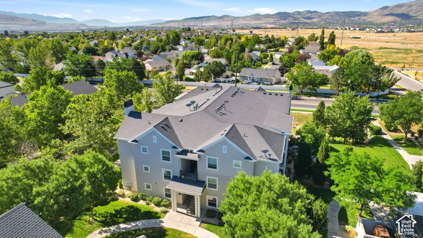 Multi-story residential building featuring light grey siding and a dark grey shingle roof