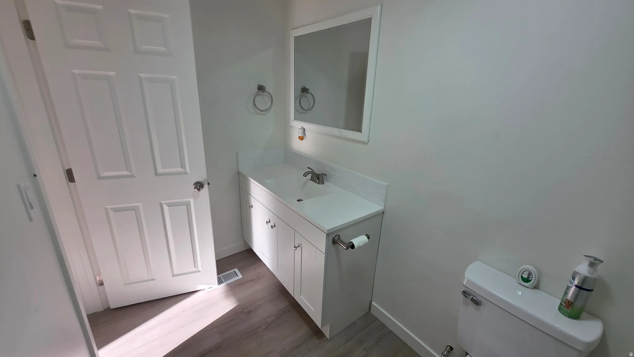 Bathroom featuring a white vanity with integrated sink, chrome faucet, and coordinating mirror