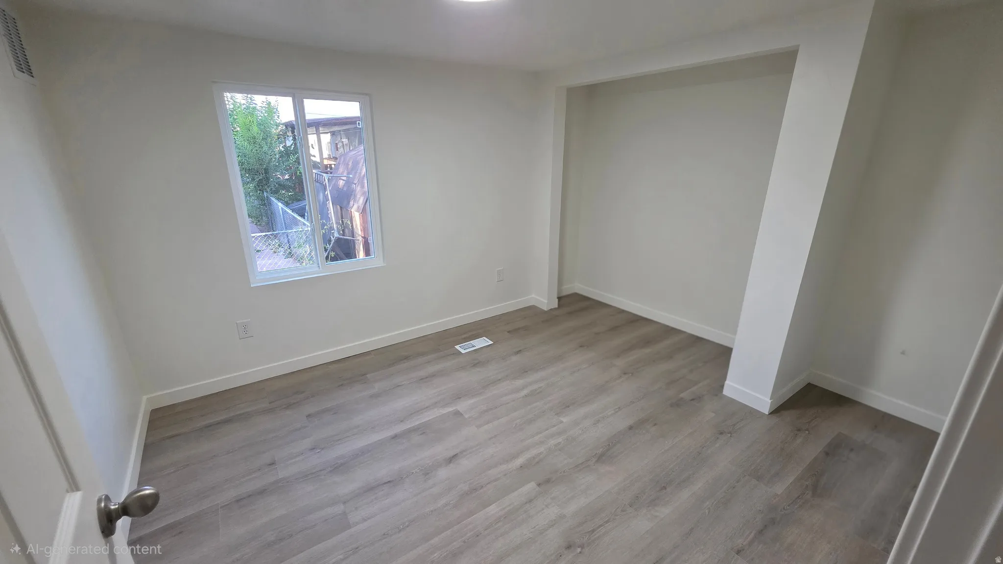 Room featuring wood-finish flooring, white baseboards, and a single window with a white frame