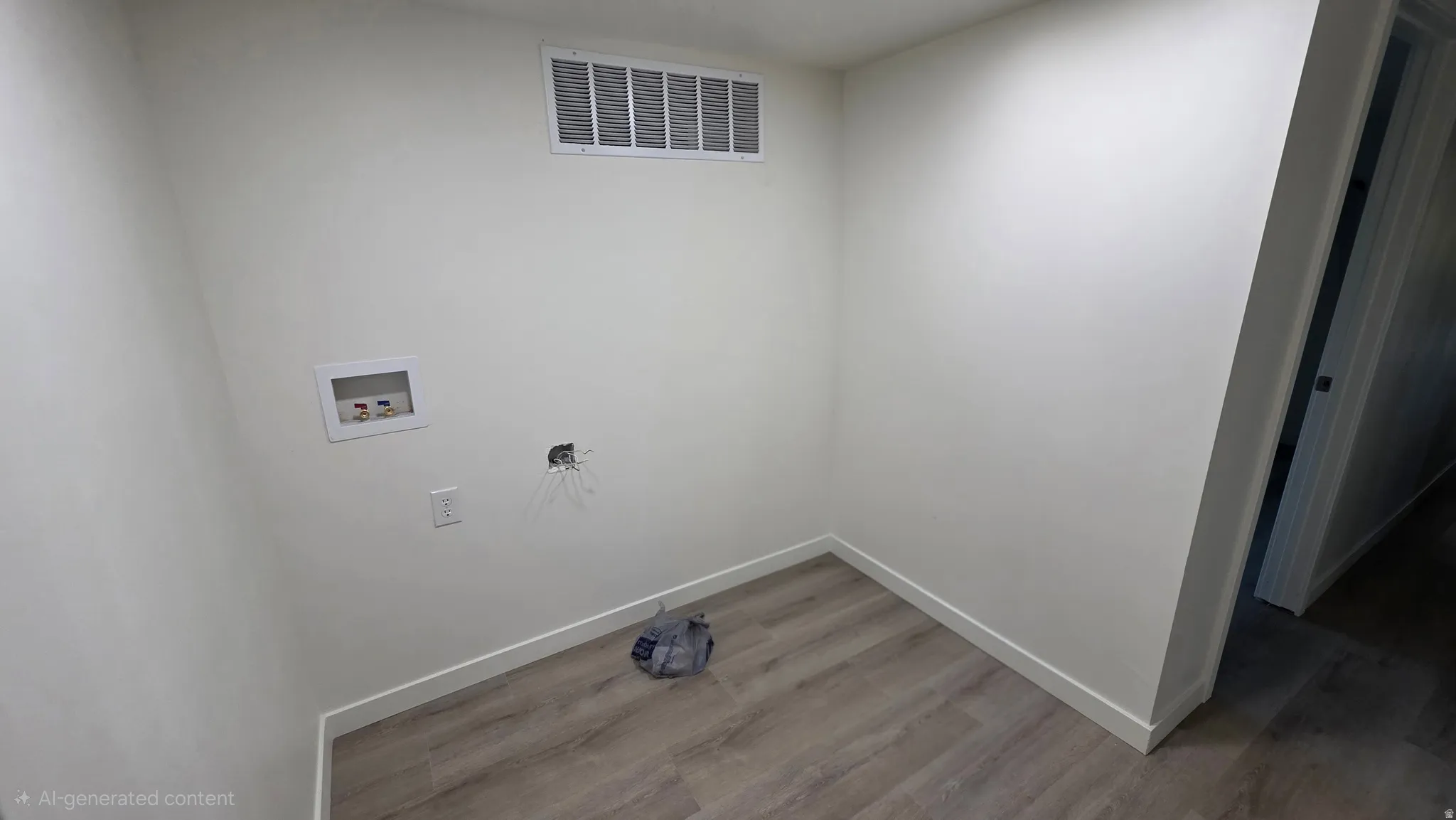 Dedicated utility area featuring wood-finish flooring, light-colored walls, and a visible ventilation register