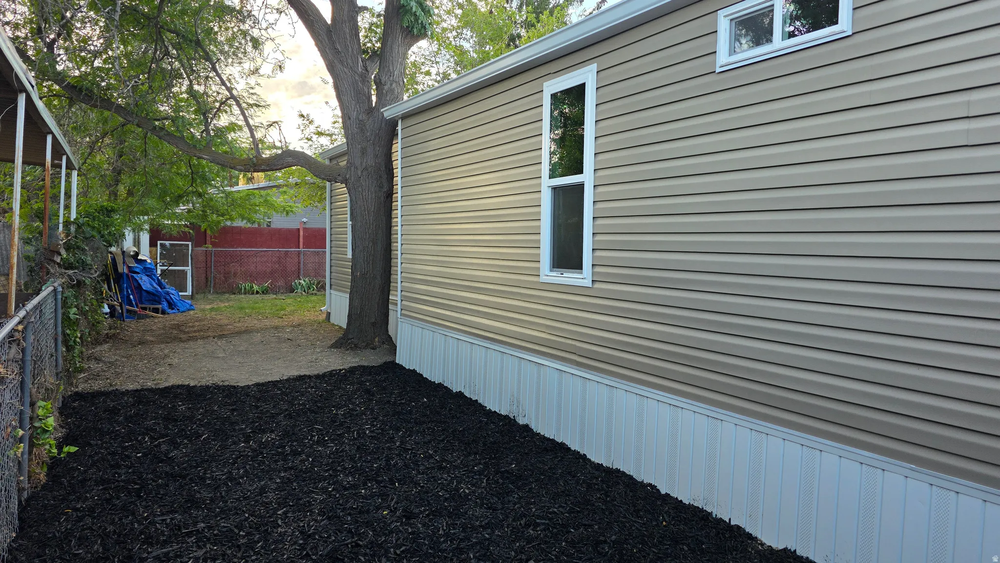 Exterior featuring horizontal beige vinyl siding with white trim around windows
