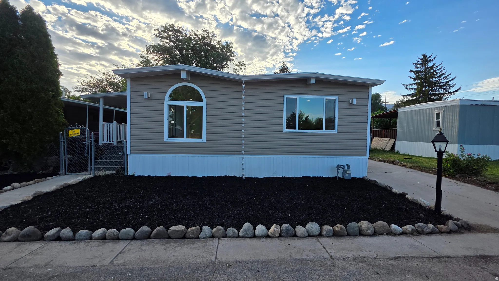Manufactured home featuring horizontal siding, white trim, and a covered side entrance