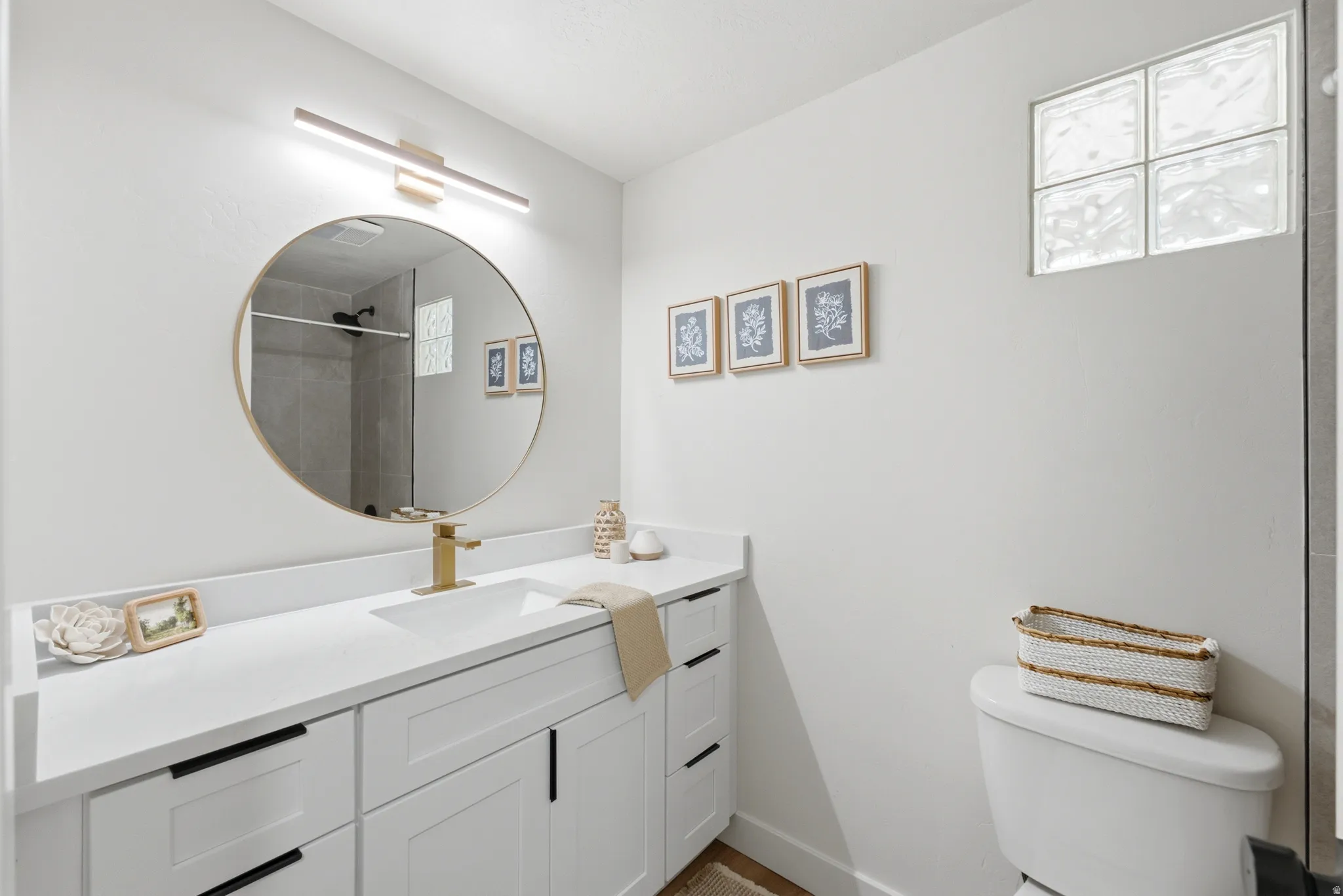 Modern bathroom featuring a white vanity with integrated sink, quartz countertop, and matte black cabinet hardware
