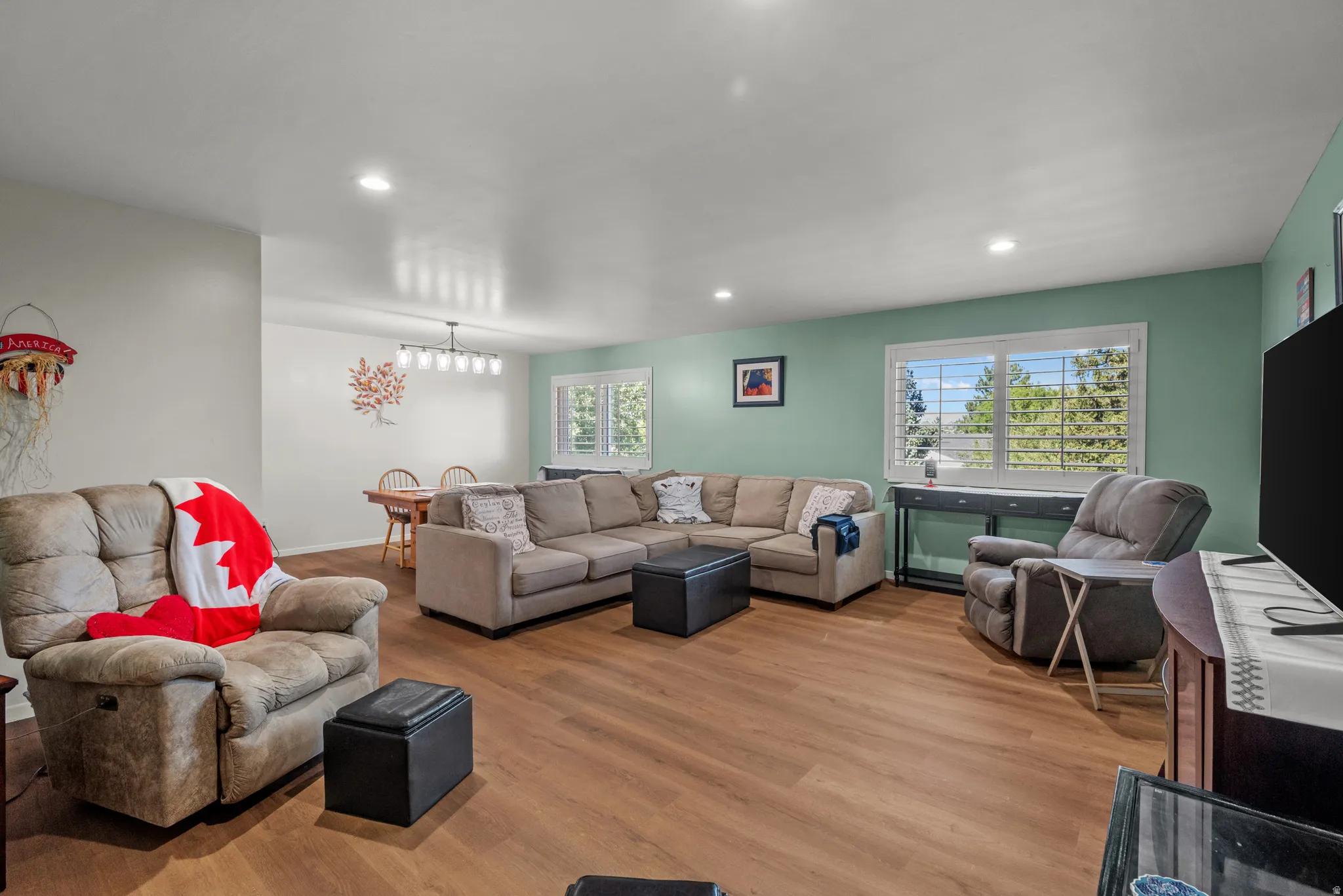 Open-concept living space featuring wood-finish flooring and recessed lighting