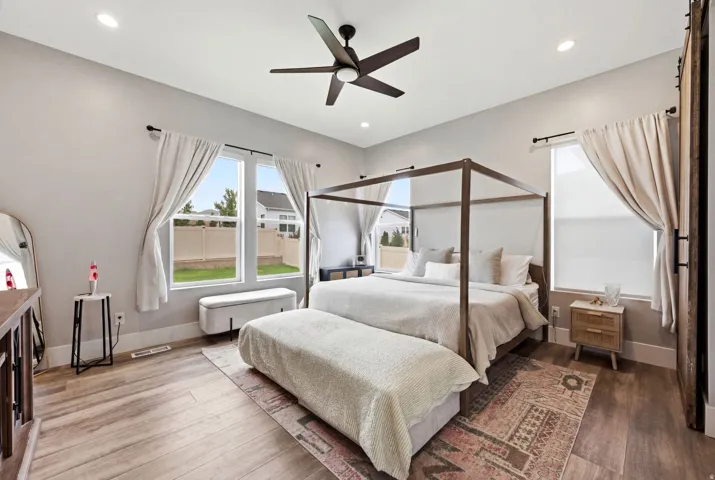 Expansive room featuring wood-finish flooring, recessed lighting, and a contemporary ceiling fan
