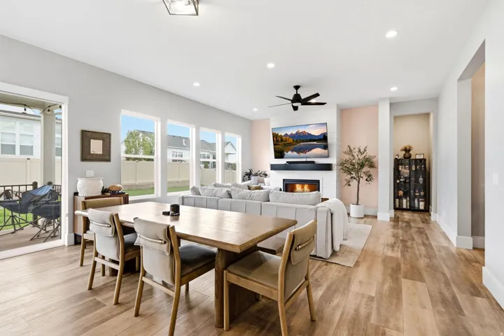 Open-concept living space with wood-finish flooring extending from the dining area to the living room