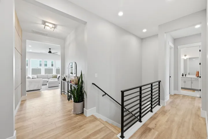 Entryway featuring wood-finish flooring, a modern black metal stair railing, recessed lighting, and a contemporary flush-mount ceiling fixture