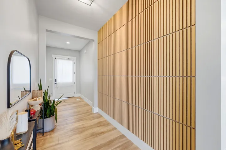 Entryway featuring a decorative wood slat accent wall, light wood-finish flooring, and a white front door