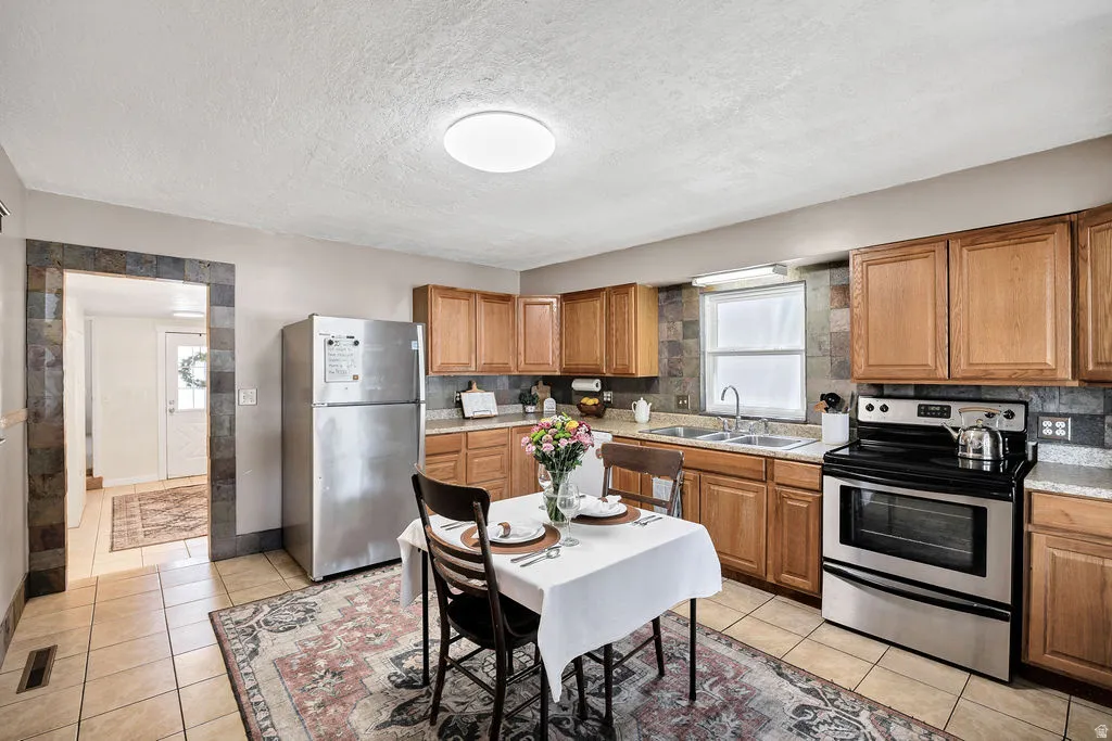 Kitchen featuring wood cabinetry, stainless steel appliances, and a tiled backsplash