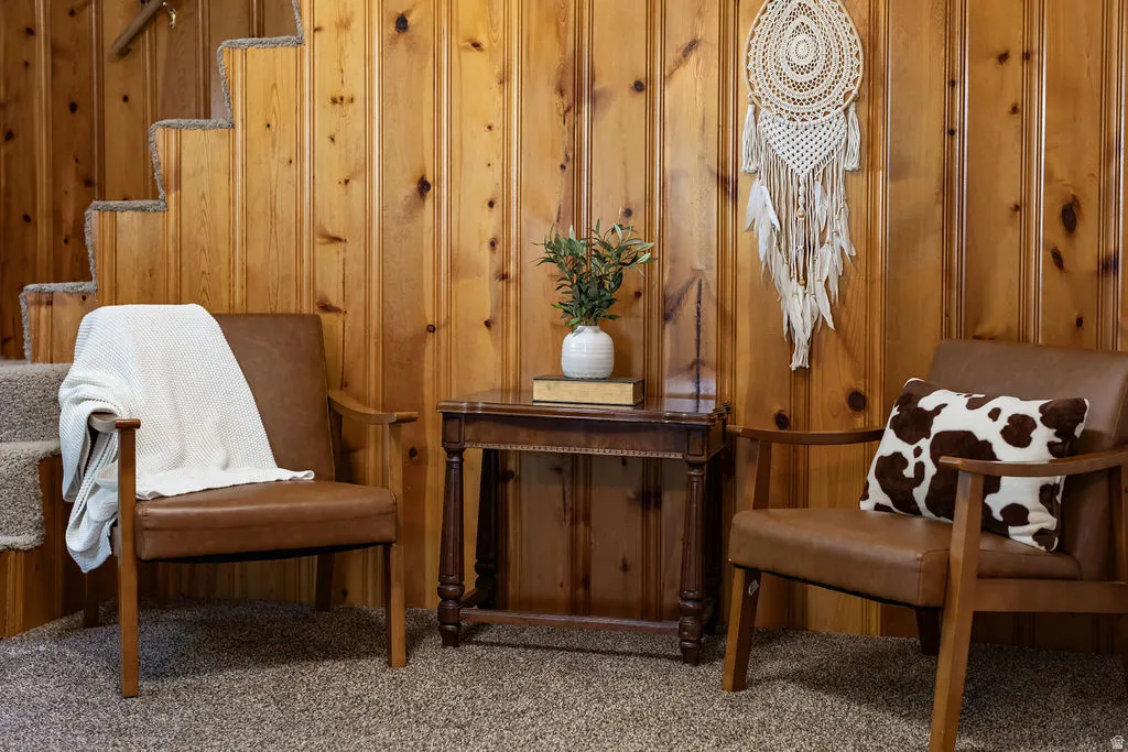 Vertical wood paneling with natural knots, complemented by a carpeted staircase