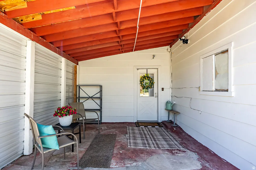 Covered carport with a white entry door