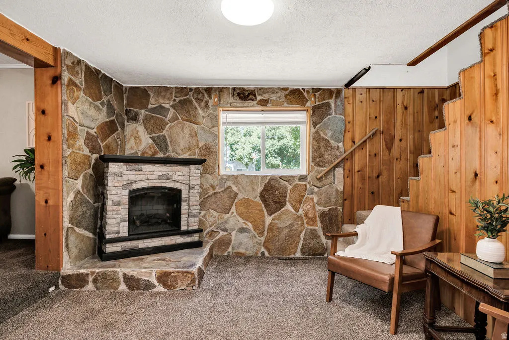 Stone accent wall with a fireplace featuring a stone hearth and mantel